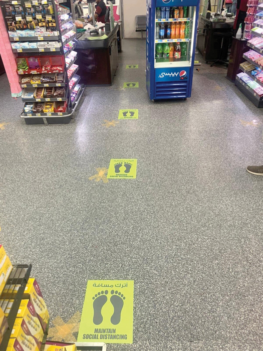 Image of floor stickers in a grocery store marking how far apart one should stand when waiting for the cashier